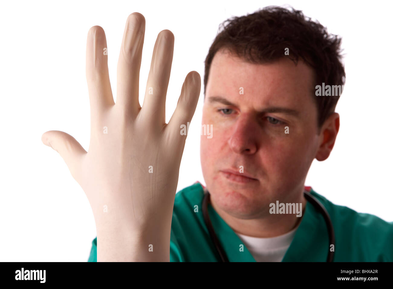 man wearing medical scrubs and stethoscope putting on a pair of rubber