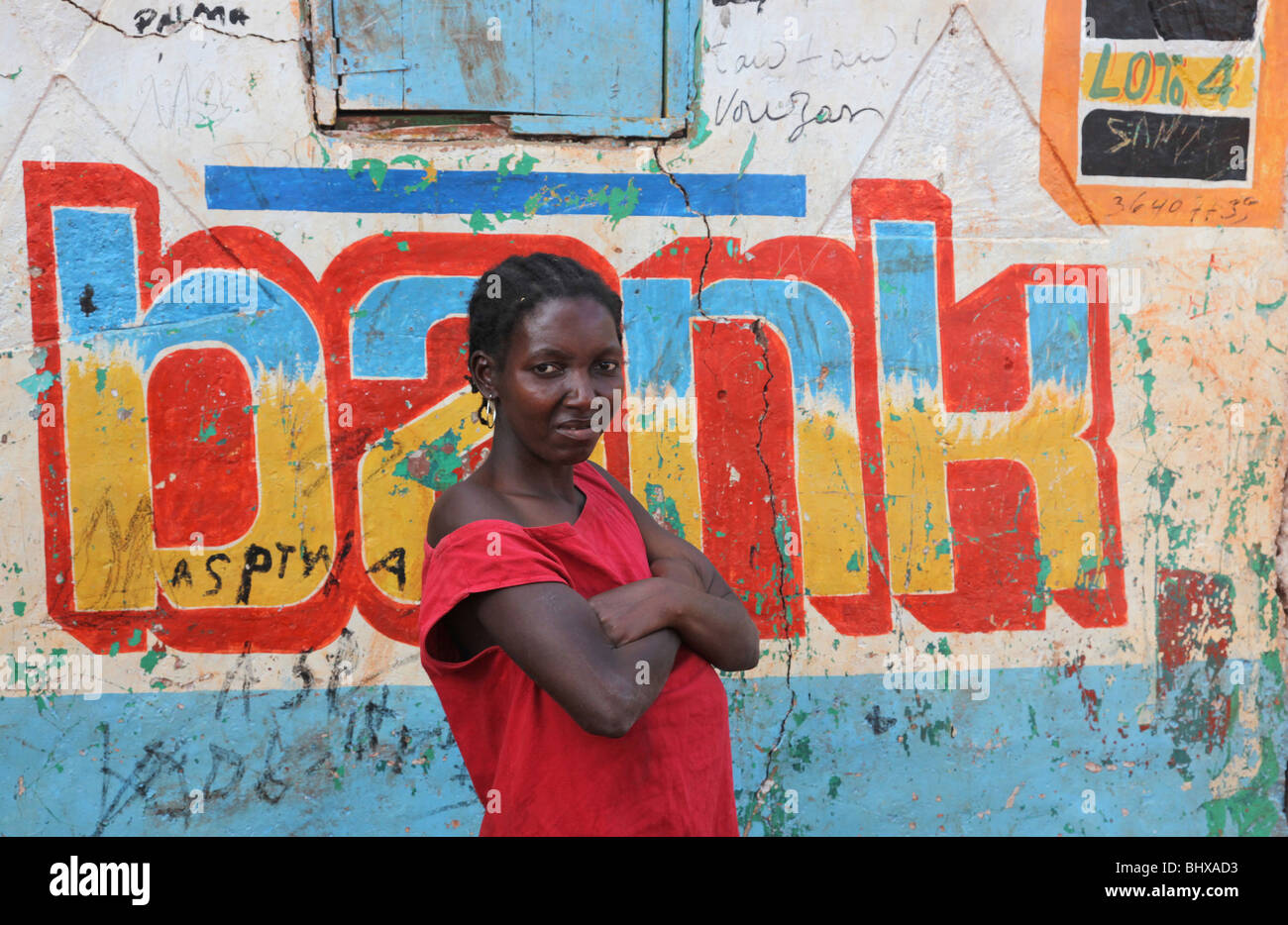 Portrait of woman outside a bank sign, Isle de la Gonave, Haiti Stock