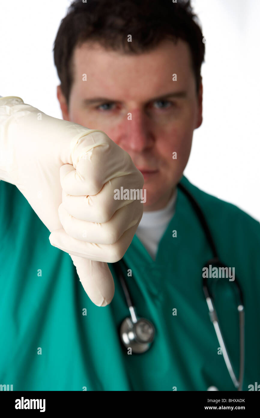 man wearing medical scrubs and stethoscope holding out thumbs down bad news gesture Stock Photo