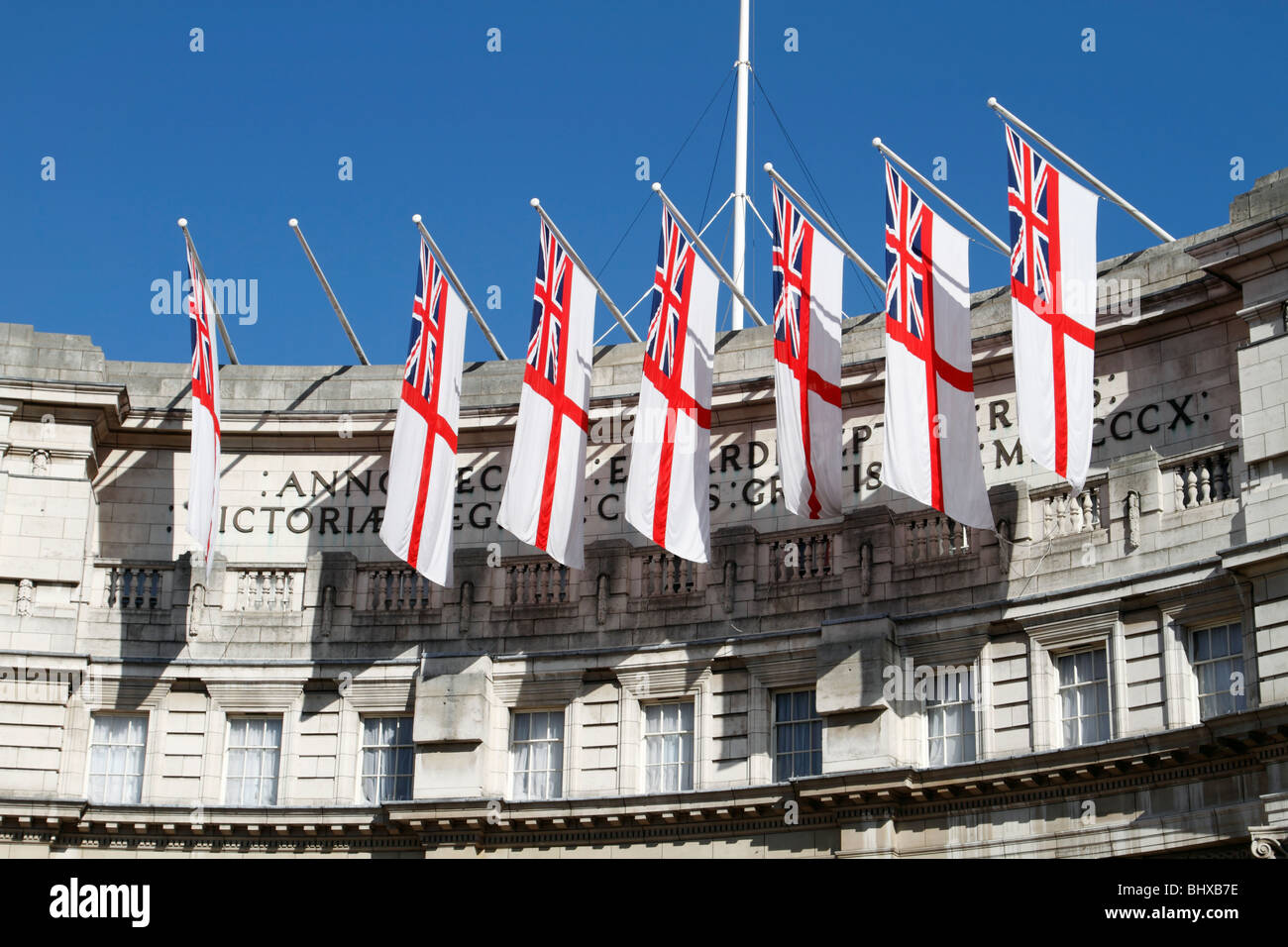 Flags hanging above Admiralty Arch at the entrance to the Mall from Trafalgar Square, London Stock Photo