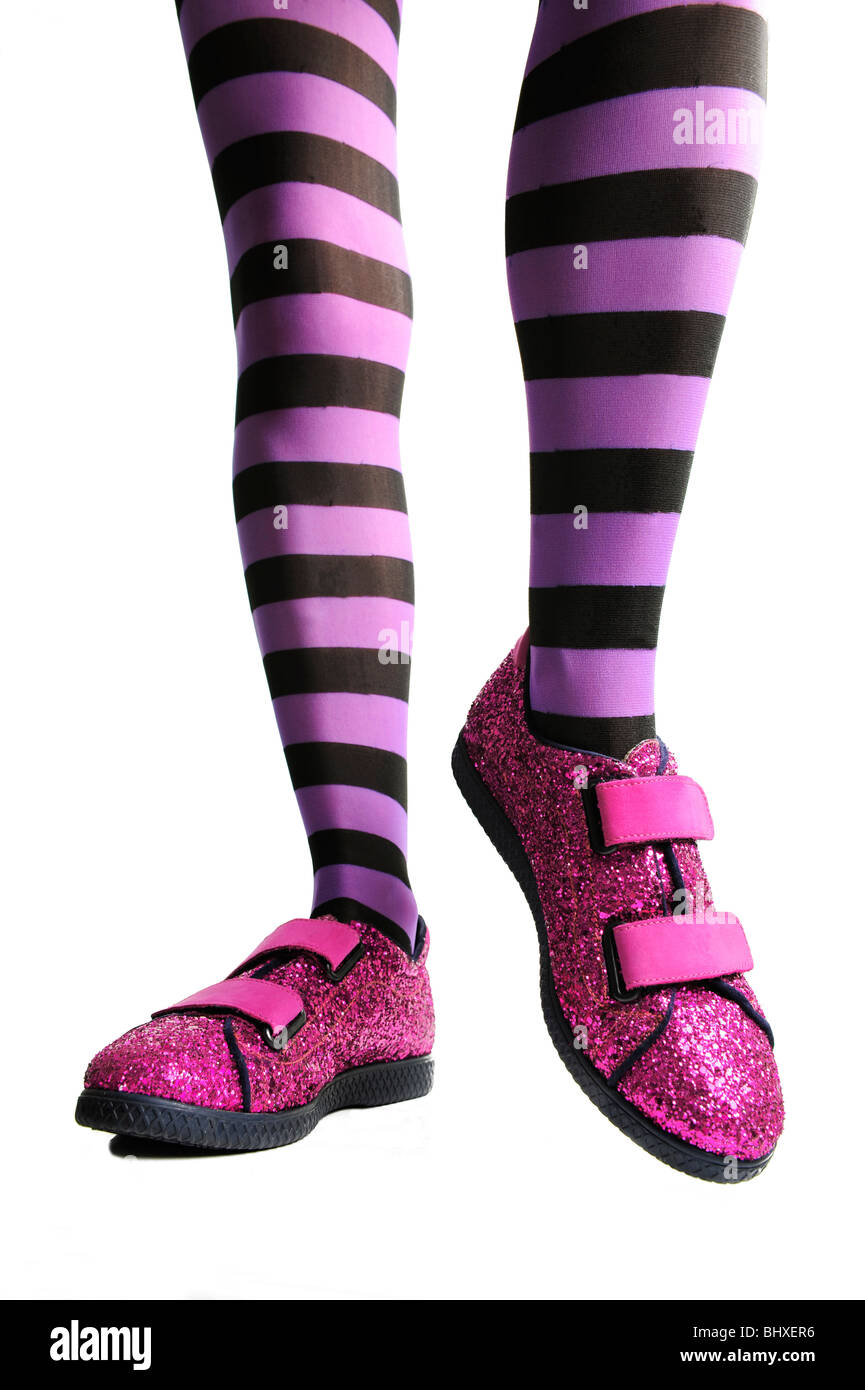 Pink sparkle shoes with woman legs in purple striped tights or pantyhose Stock Photo