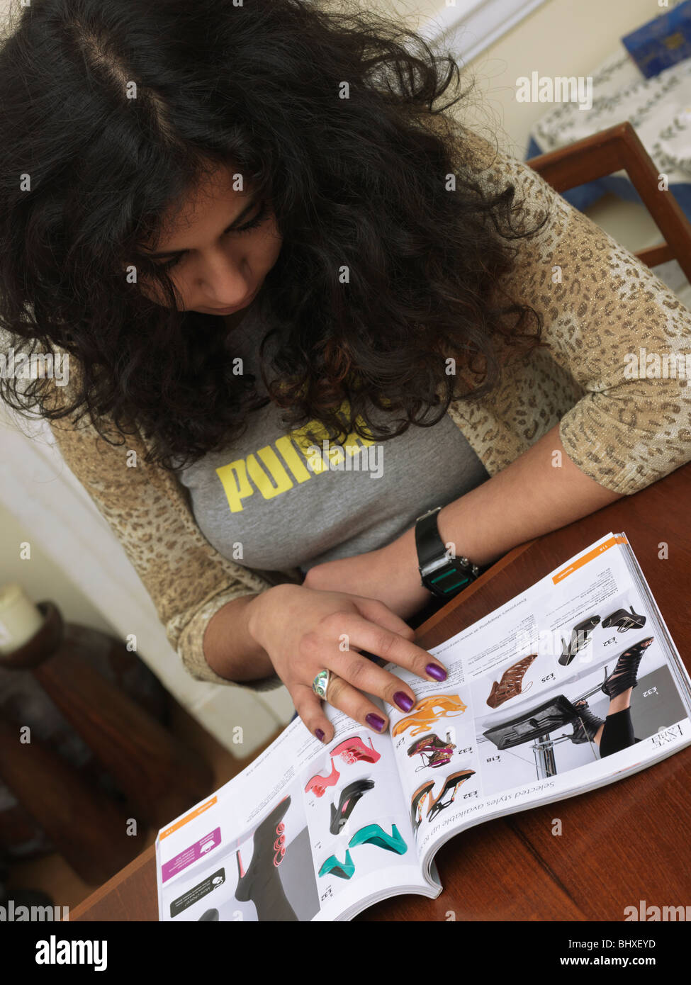 A Woman Looking Through a Mail Order Catalogue Stock Photo