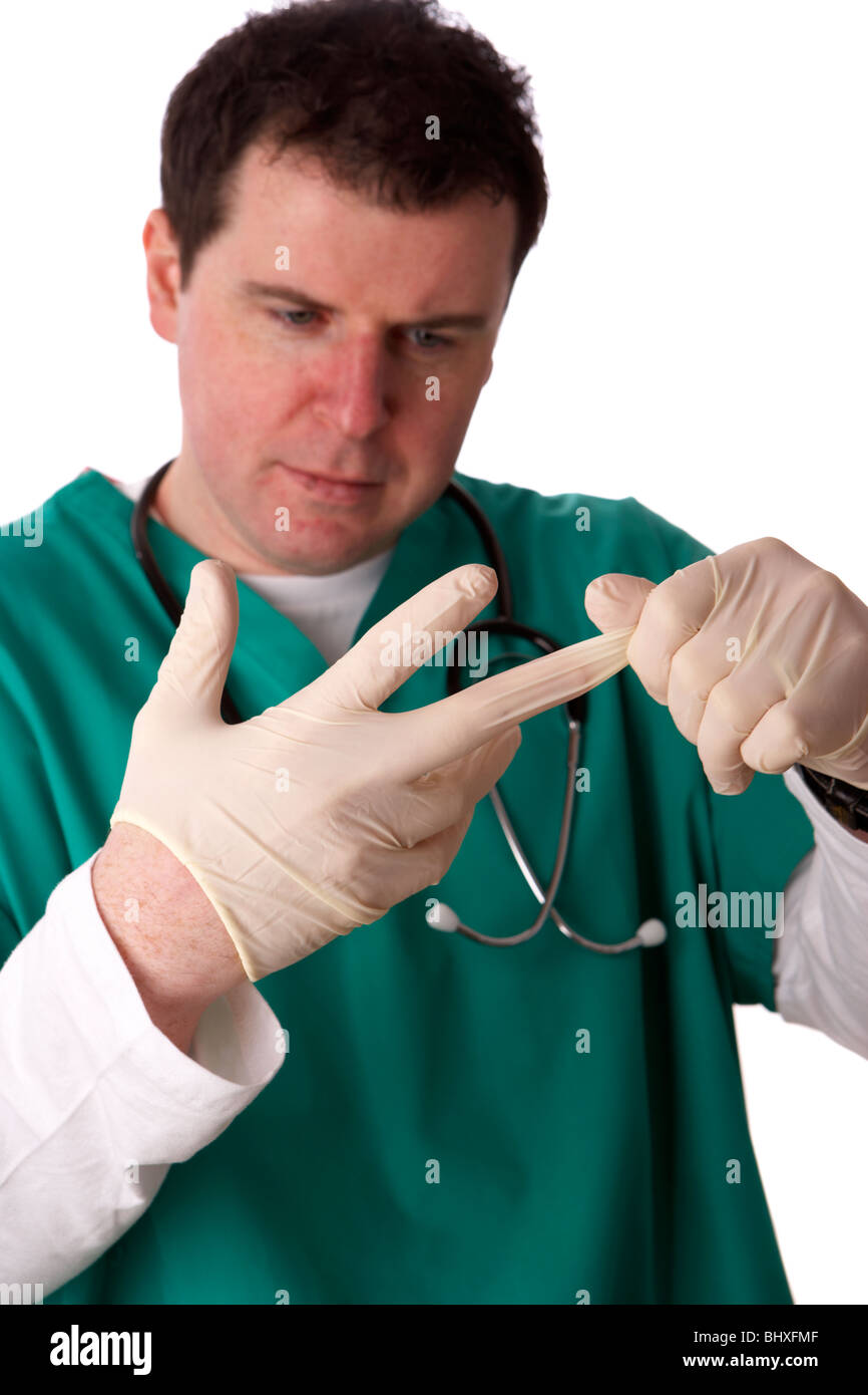 man wearing medical scrubs and stethoscope putting on a pair of rubber gloves Stock Photo
