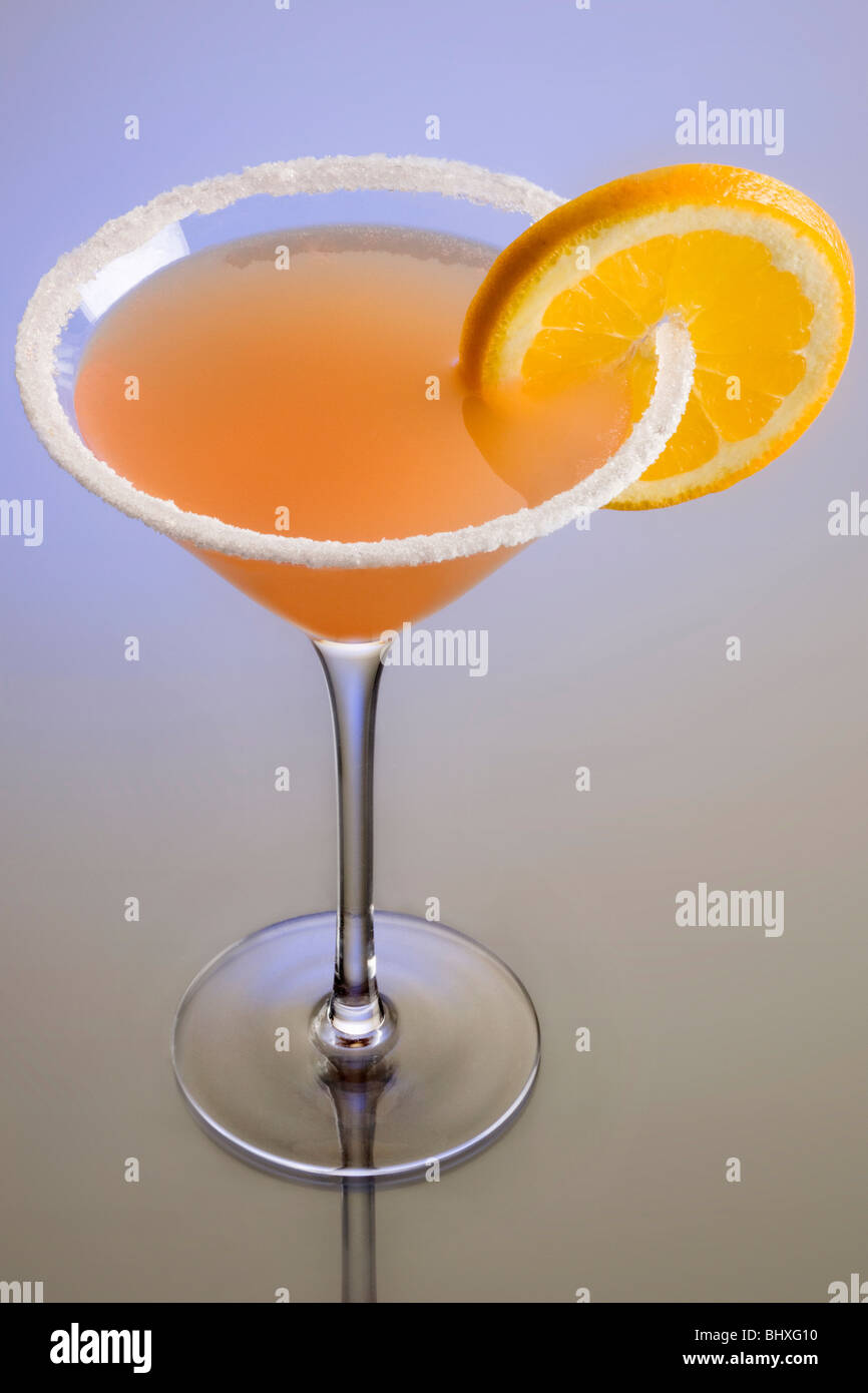 Sidecar mixed drink with orange garnish and sugar rim on plain