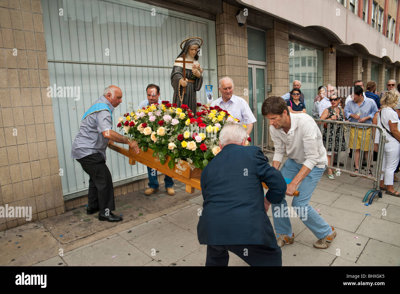 Statue Hoisting Men lift a statue to put it on to their shoulders for the procession in ...