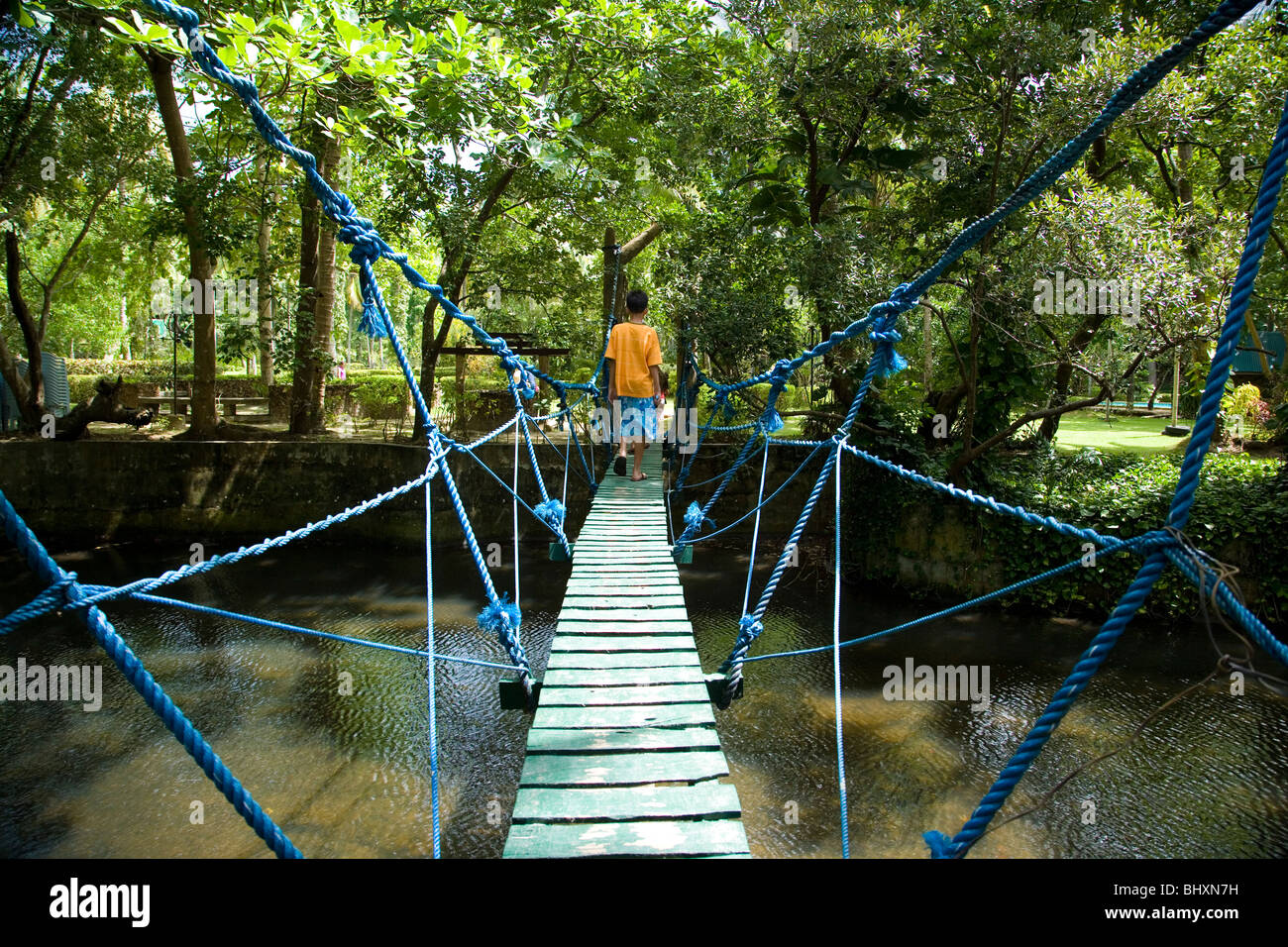 A man crosses a hangging bridge Stock Photo - Alamy