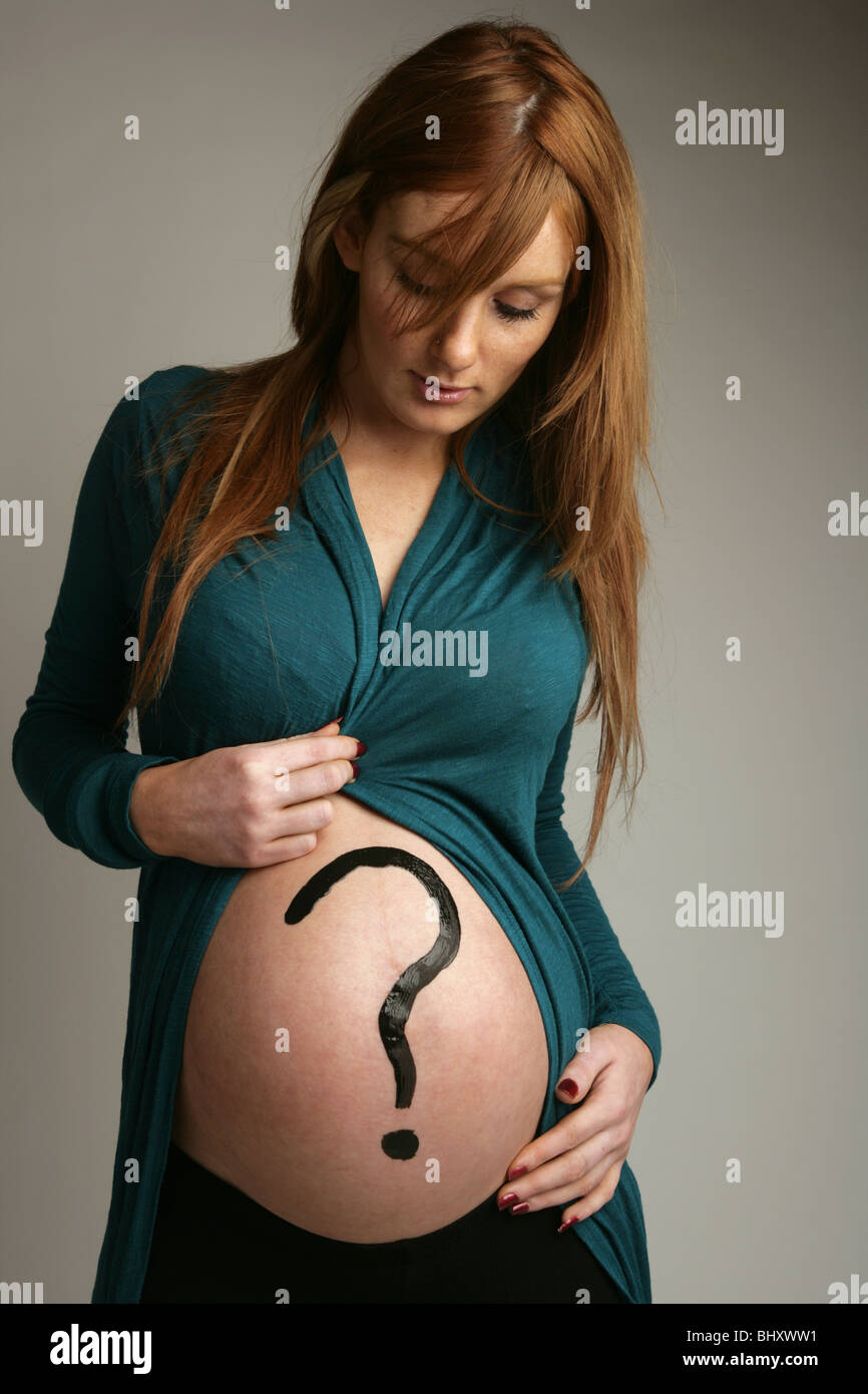 Woman Nine months pregnant with a question mark drawn on her tummy Stock Photo