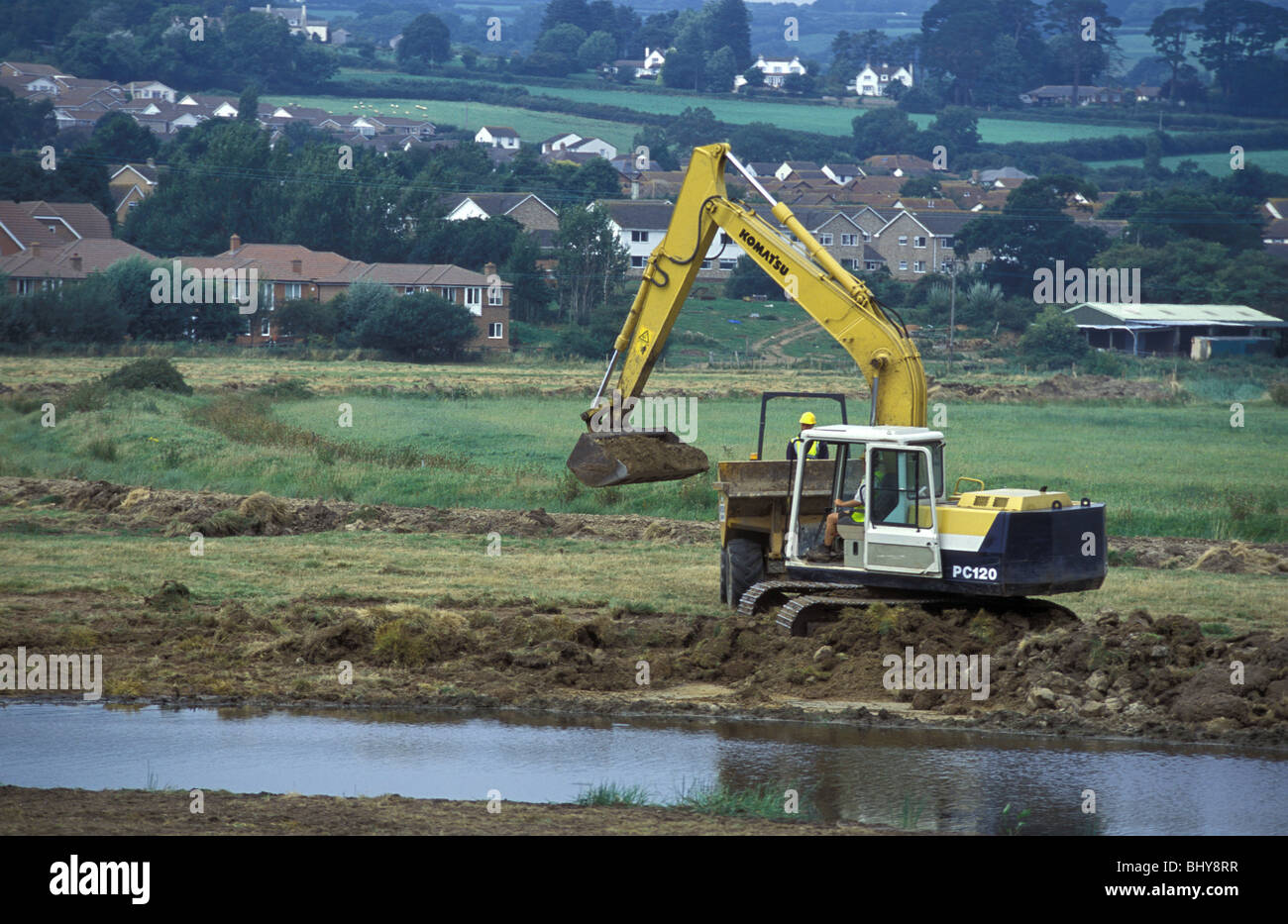 A pond for waders and waterfowl being dug at Seaton Local Nature Reserve Devon England Stock Photo