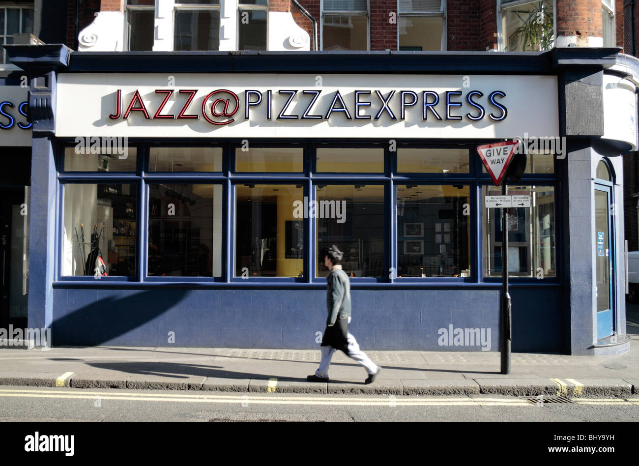 Man walking past the shop front to the Jazz @ Pizza Express restaurant in Dean Street, Soho, London, UK. Nov 2009 Stock Photo