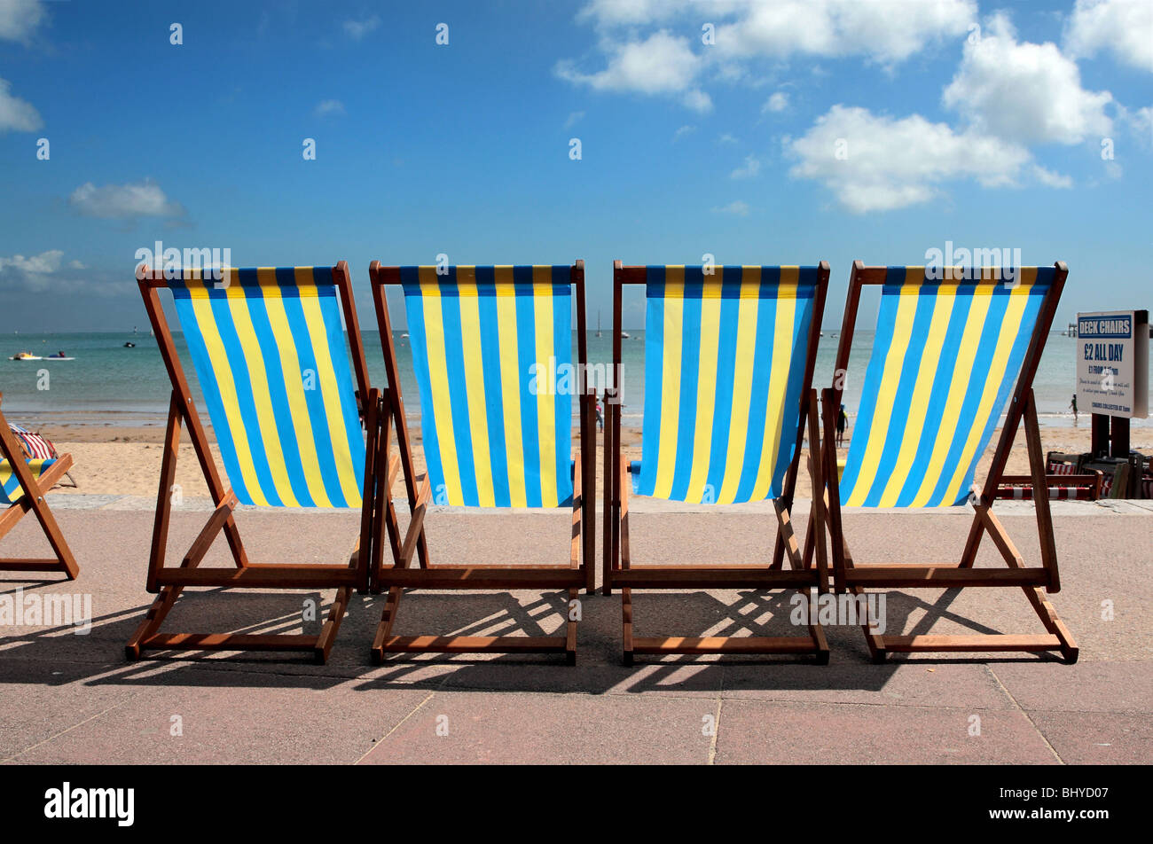 Row Of Blue And Yellow Striped Deck Chairs On The Promenade