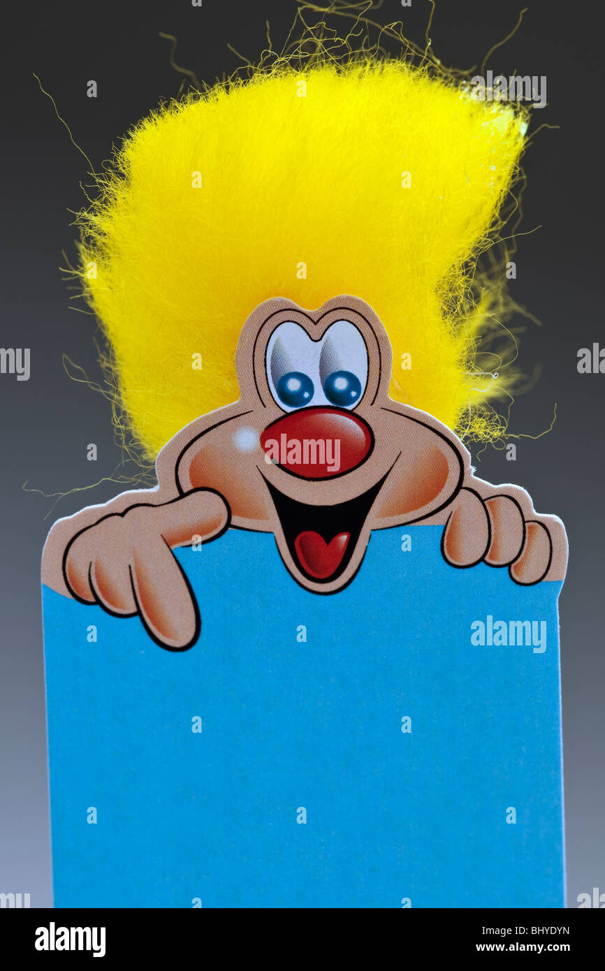 Smiling yellow bushy haired cartoon character pointing downwards Stock Photo