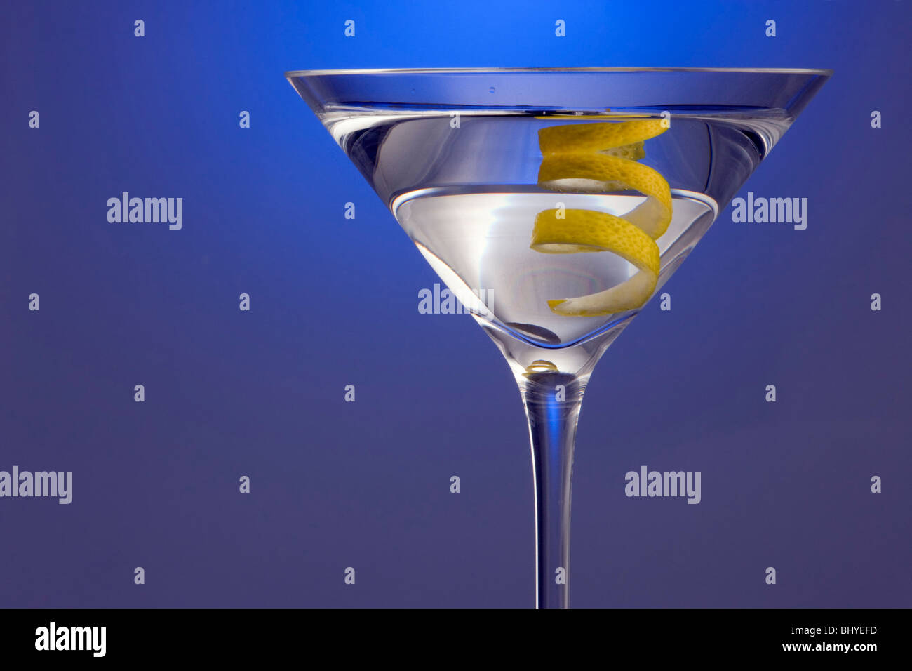 Spotlighted Straight up Martini with Lemon Twist Garnish on Blue