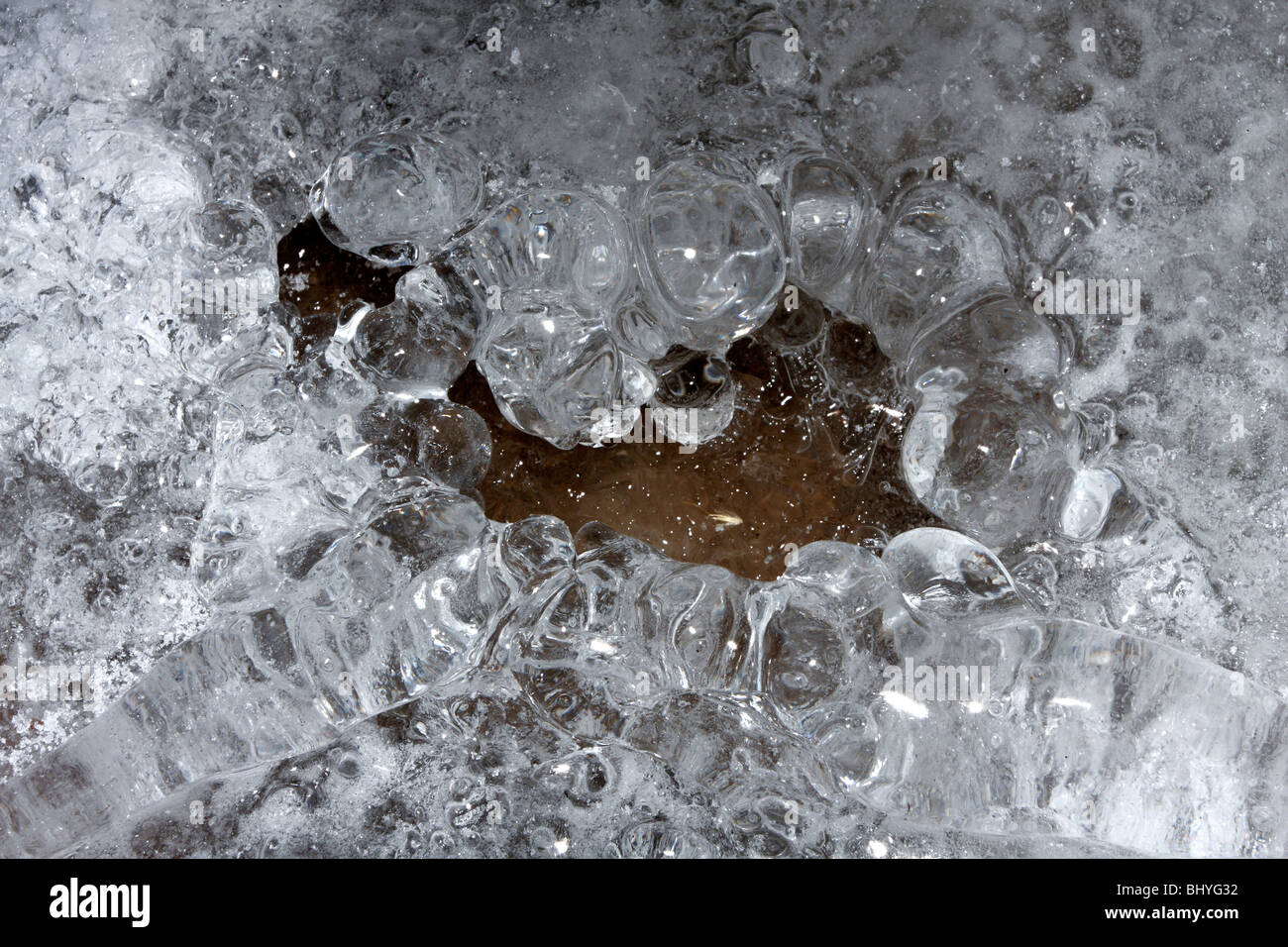 Pit created by falling water, ice nodules and crystals. Stock Photo