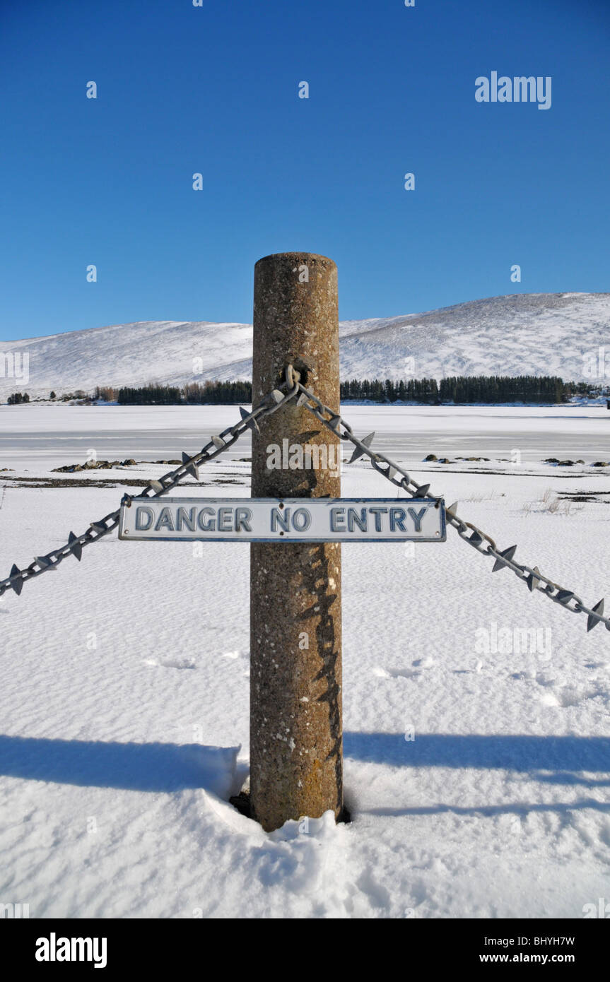 'Danger no entry' sign in front of a frozen Backwater reservoir in Glen Isla, which supplies  water to Angus and Dundee Stock Photo