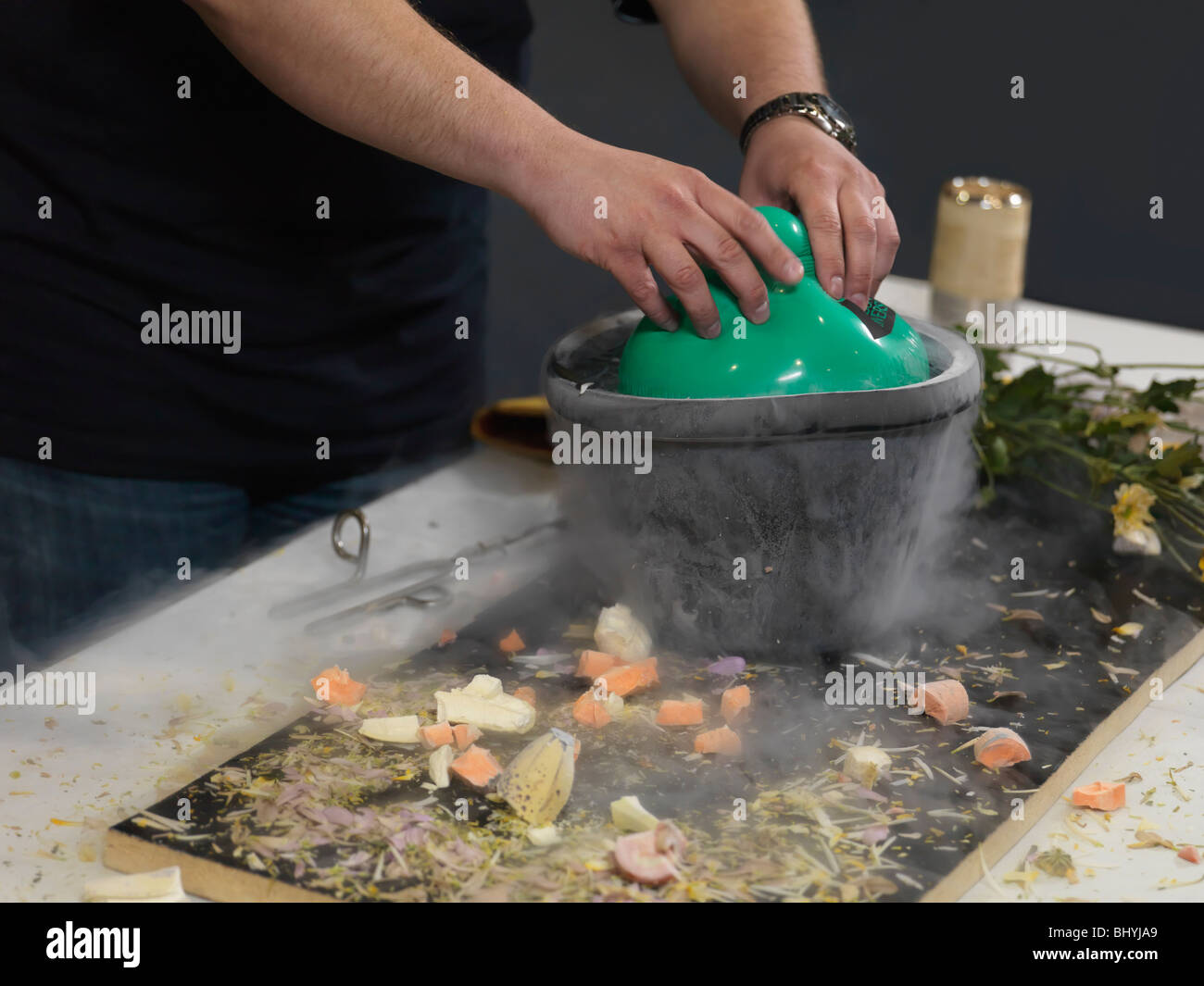 Person submerging an air balloon into a container with liquid nitrogen Stock Photo