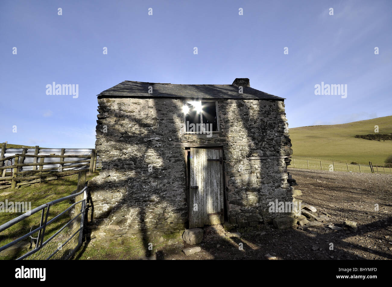 Welsh eerie barn with tree shadows Stock Photo
