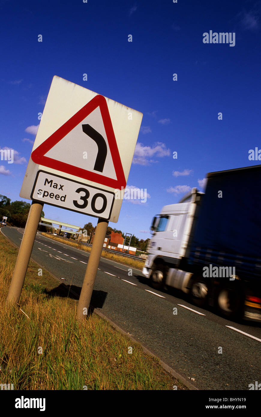 lorry passing warning sign of 30 mph speed limit and sharp left hand
