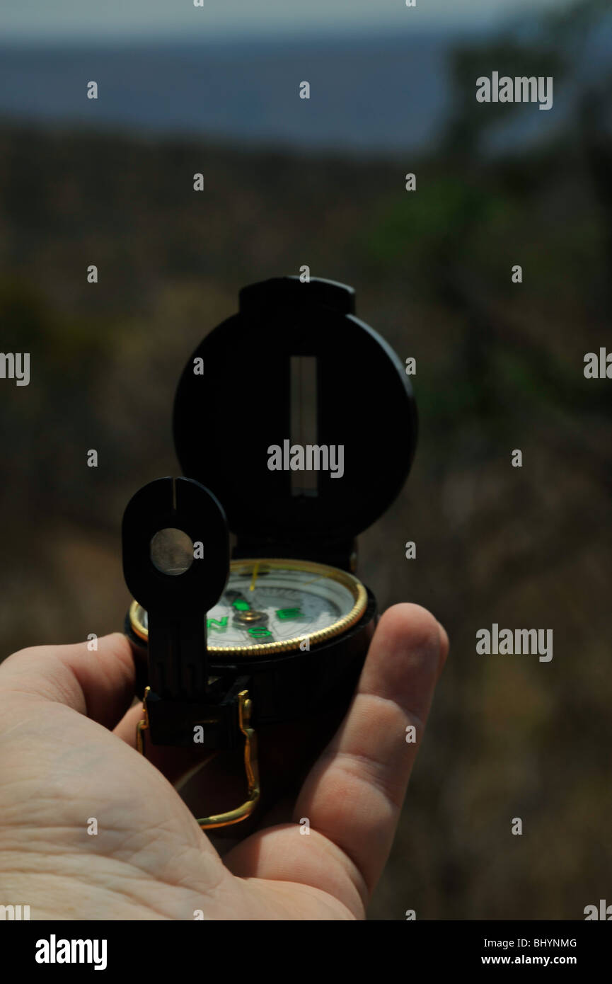 Scene of hand holding field compass taking a navigation