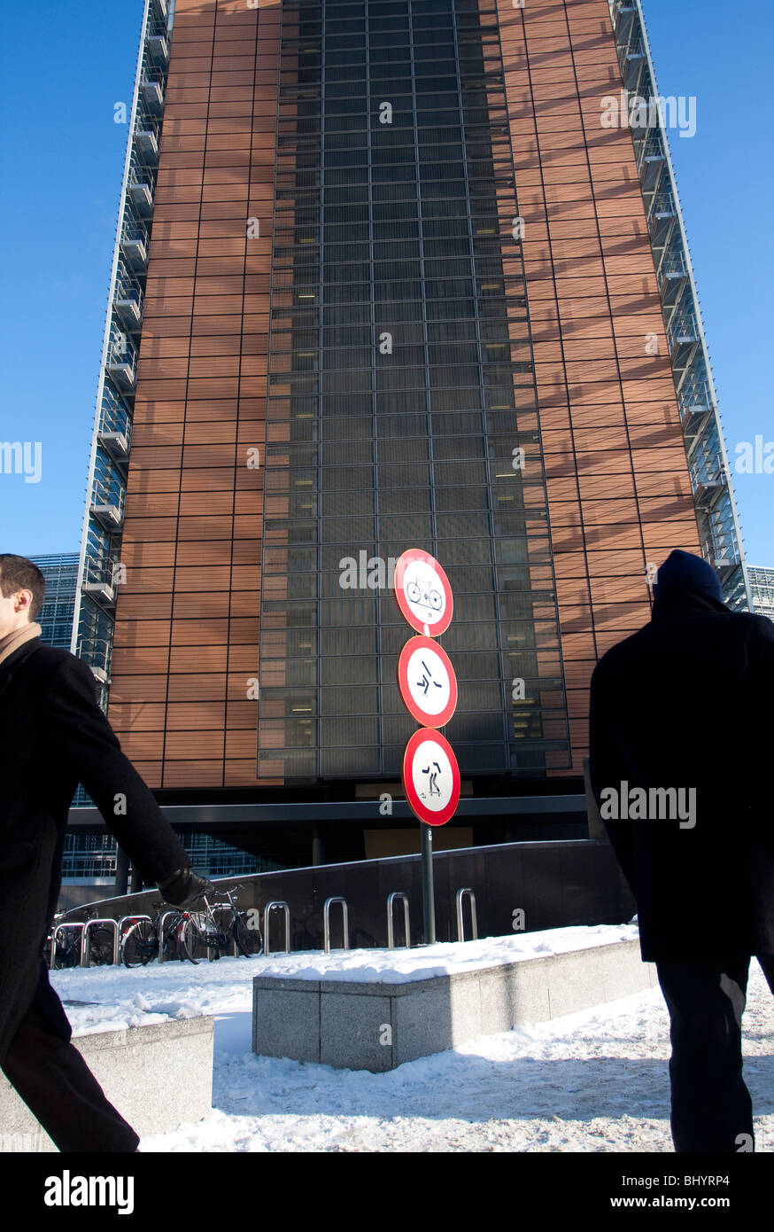 Two men walk next to the Berlaymont building, the European Commission headquarters in Brussels, Belgium. Stock Photo