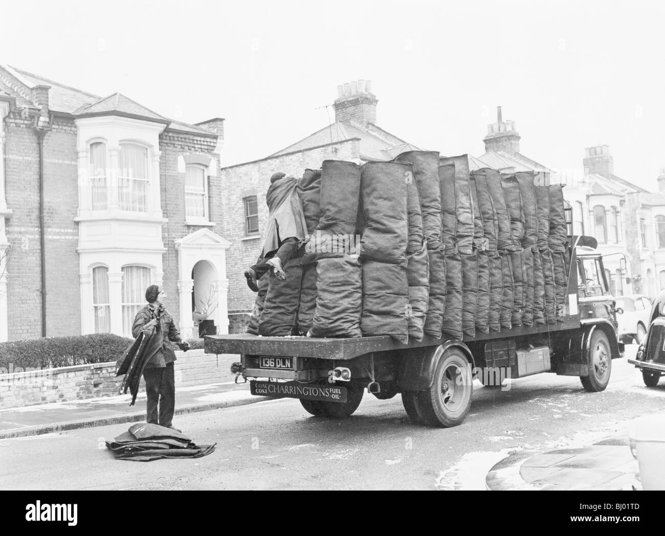 Charringtons delivering sacks of coal down a residential street. Artist: Unknown Stock Photo