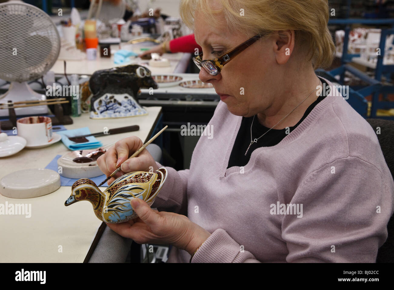 Royal Crown Derby factory, Derby - gilder Julie Towell putting the finishing touches to a duck paperweight. Stock Photo