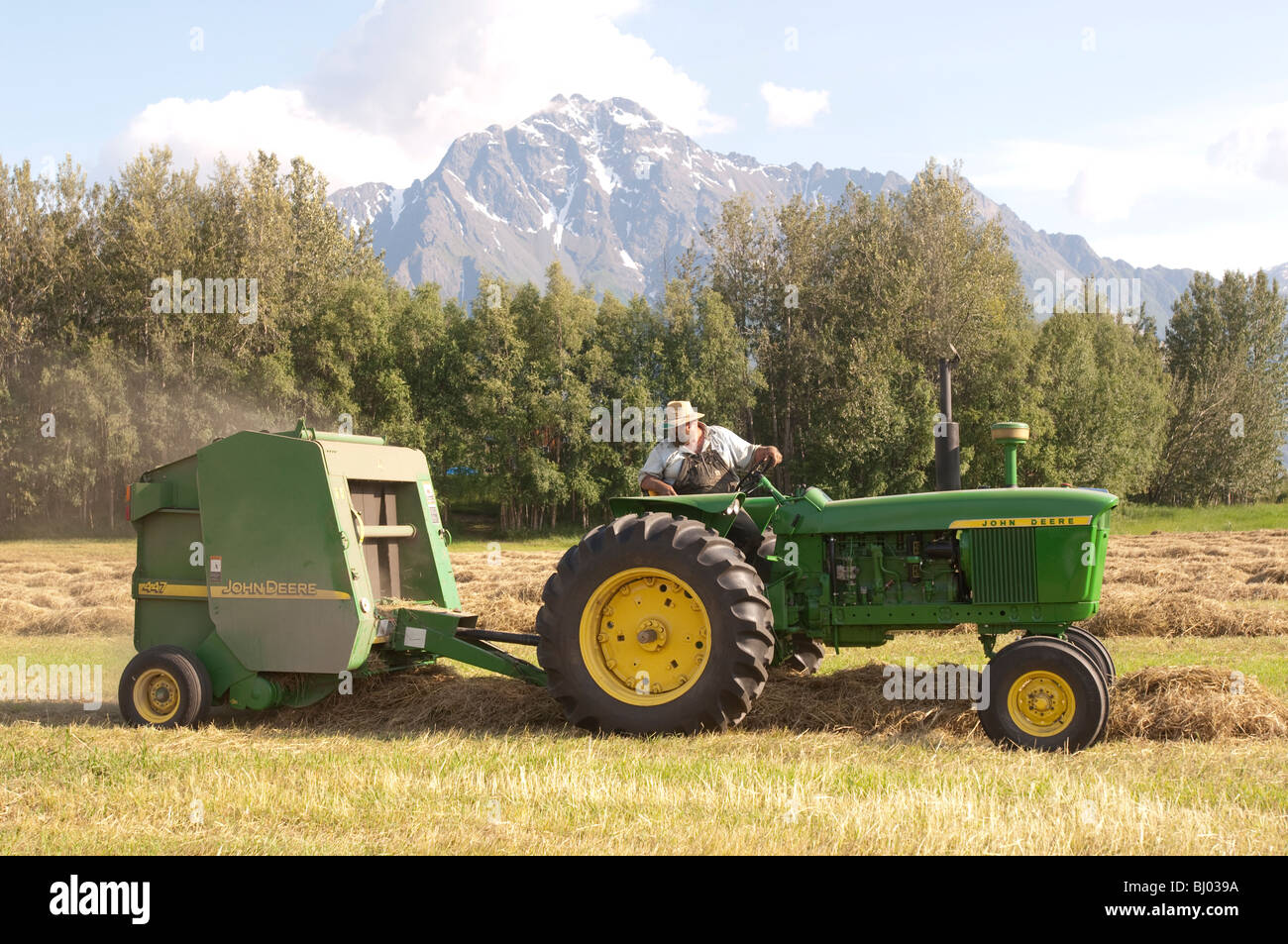 Tim McGinn of Broken Spoke Farm baling hay, Palmer Alaska Stock Photo