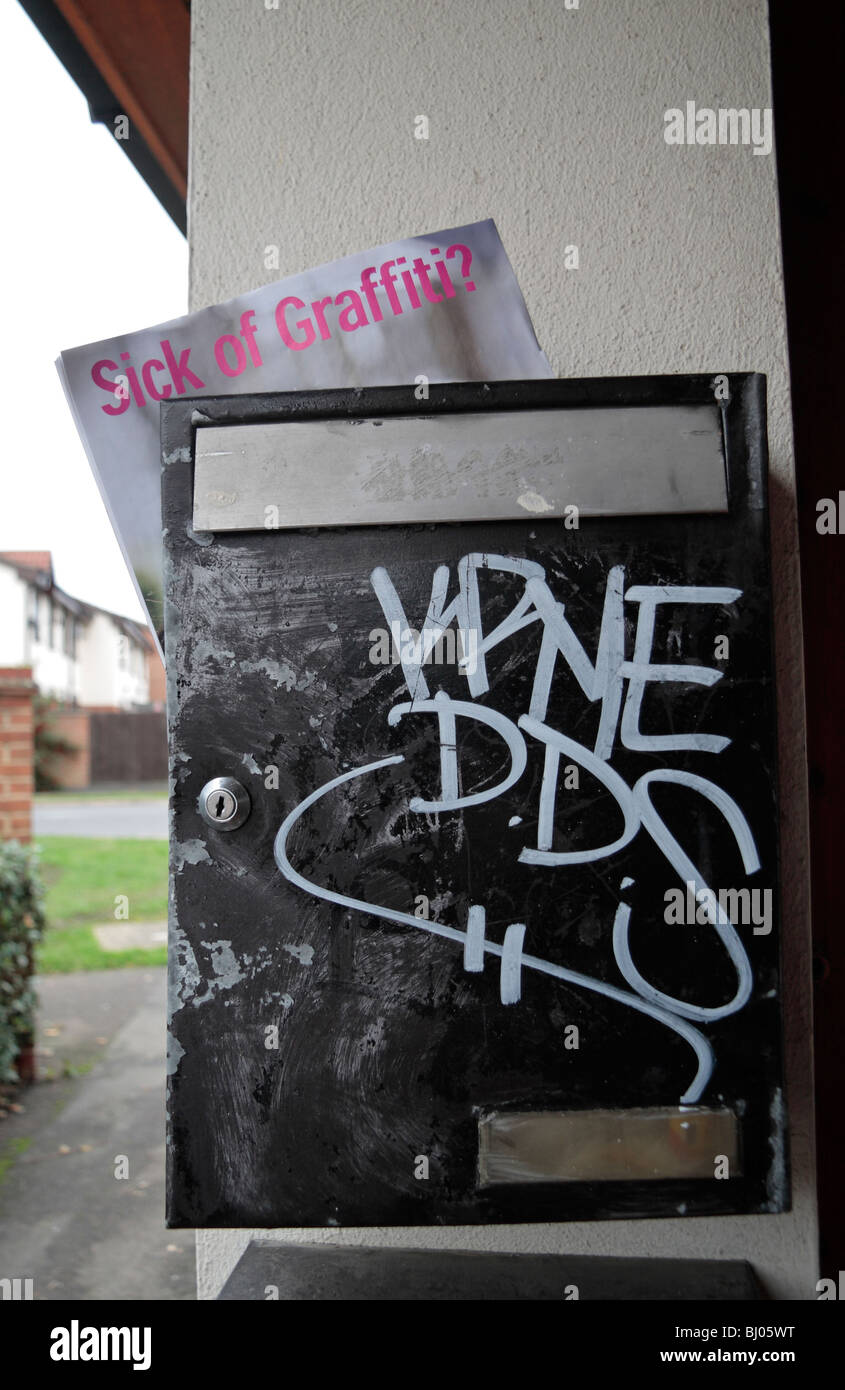 Vandalised post box outside flats in Hounslow, west London, UK.  A local council magazine about graffitti is visible. Stock Photo
