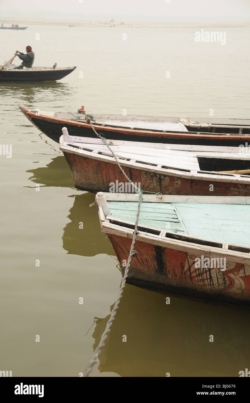 Boats lined up, moored at the edge of the ganges river in varanasi, india Stock Photo