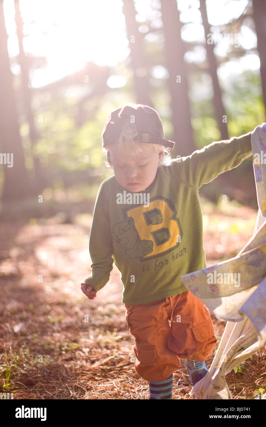 Young boy carrying a blanket in the woods Stock Photo Alamy