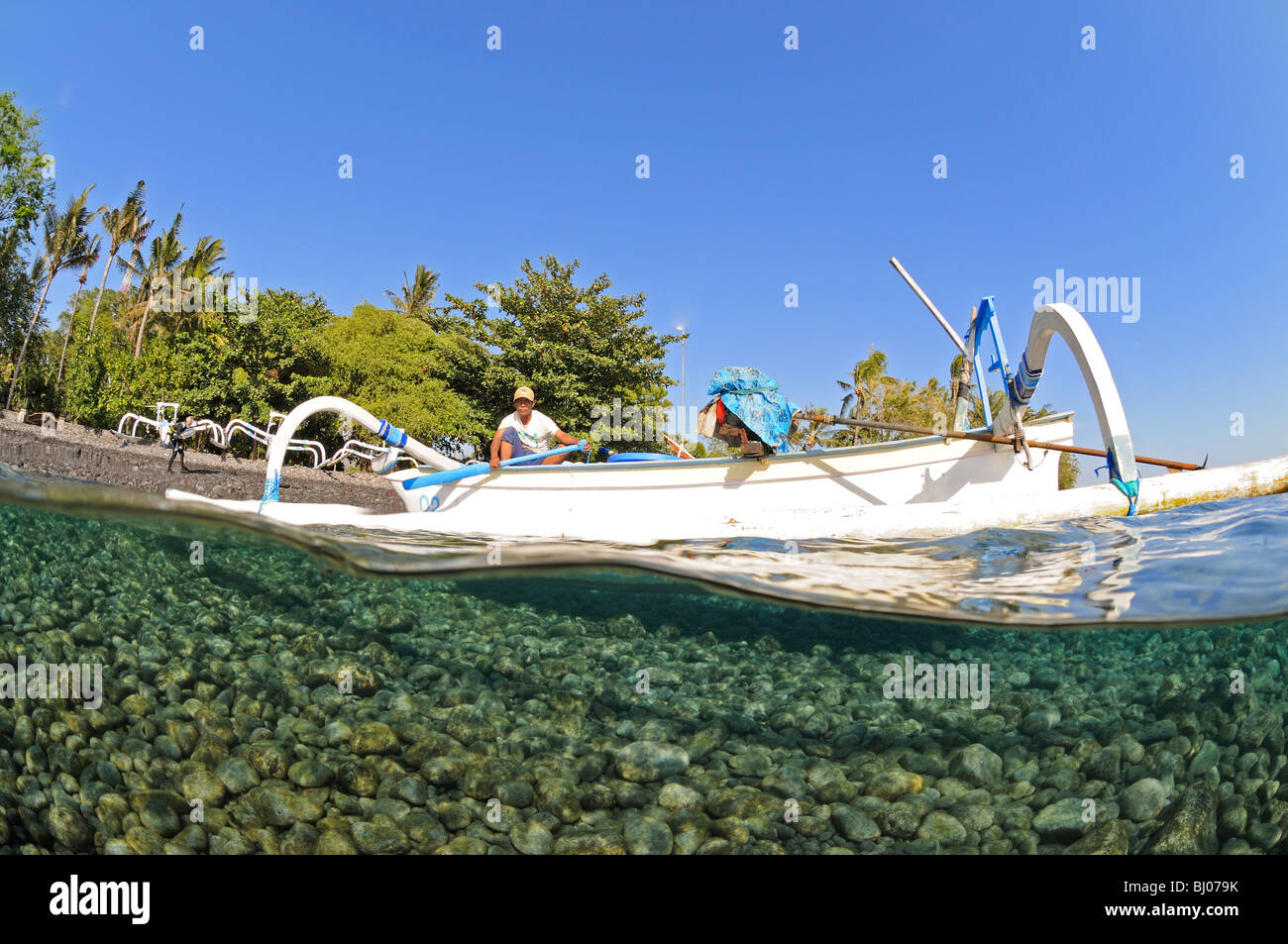 split shot of Outrigger-Canoe with fisherman, Bali, Indonesia, Indo-Pacific Ocean Stock Photo