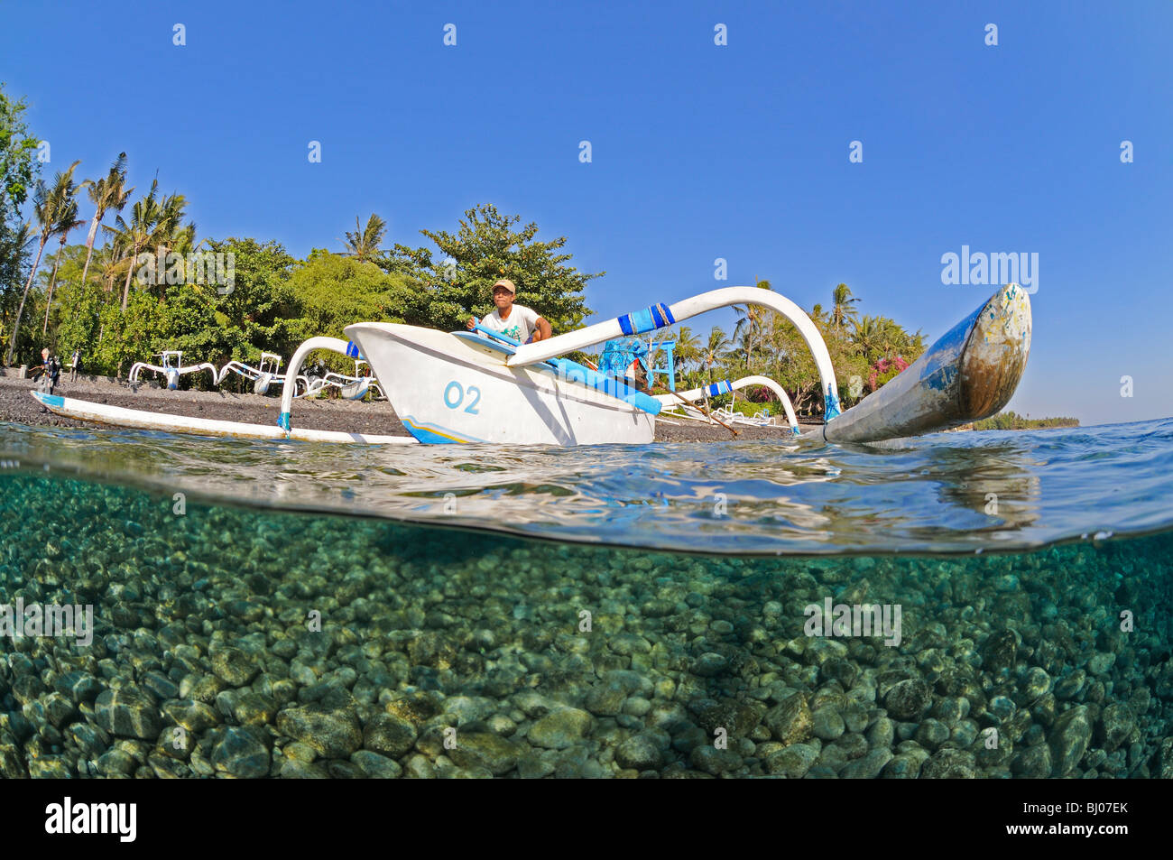 split shot of Outrigger-Canoe with fisherman, Bali, Indonesia, Indo-Pacific Ocean Stock Photo