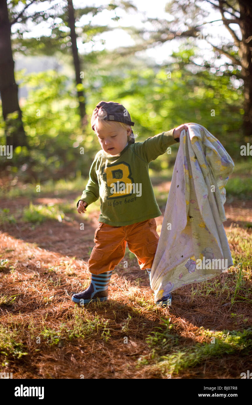 Young boy carrying a blanket in the woods Stock Photo Alamy