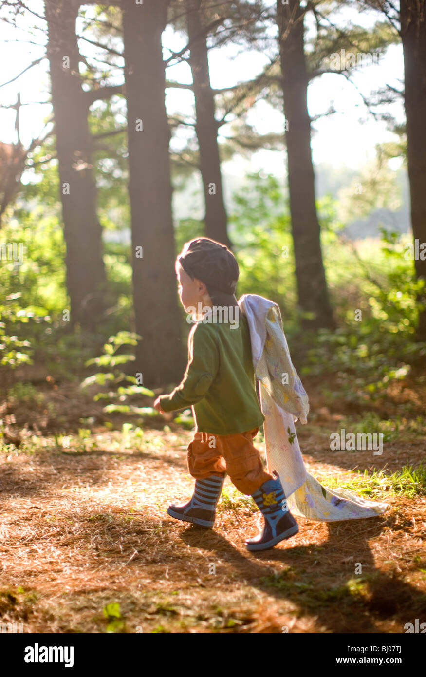 Young boy carrying a blanket in the woods Stock Photo Alamy