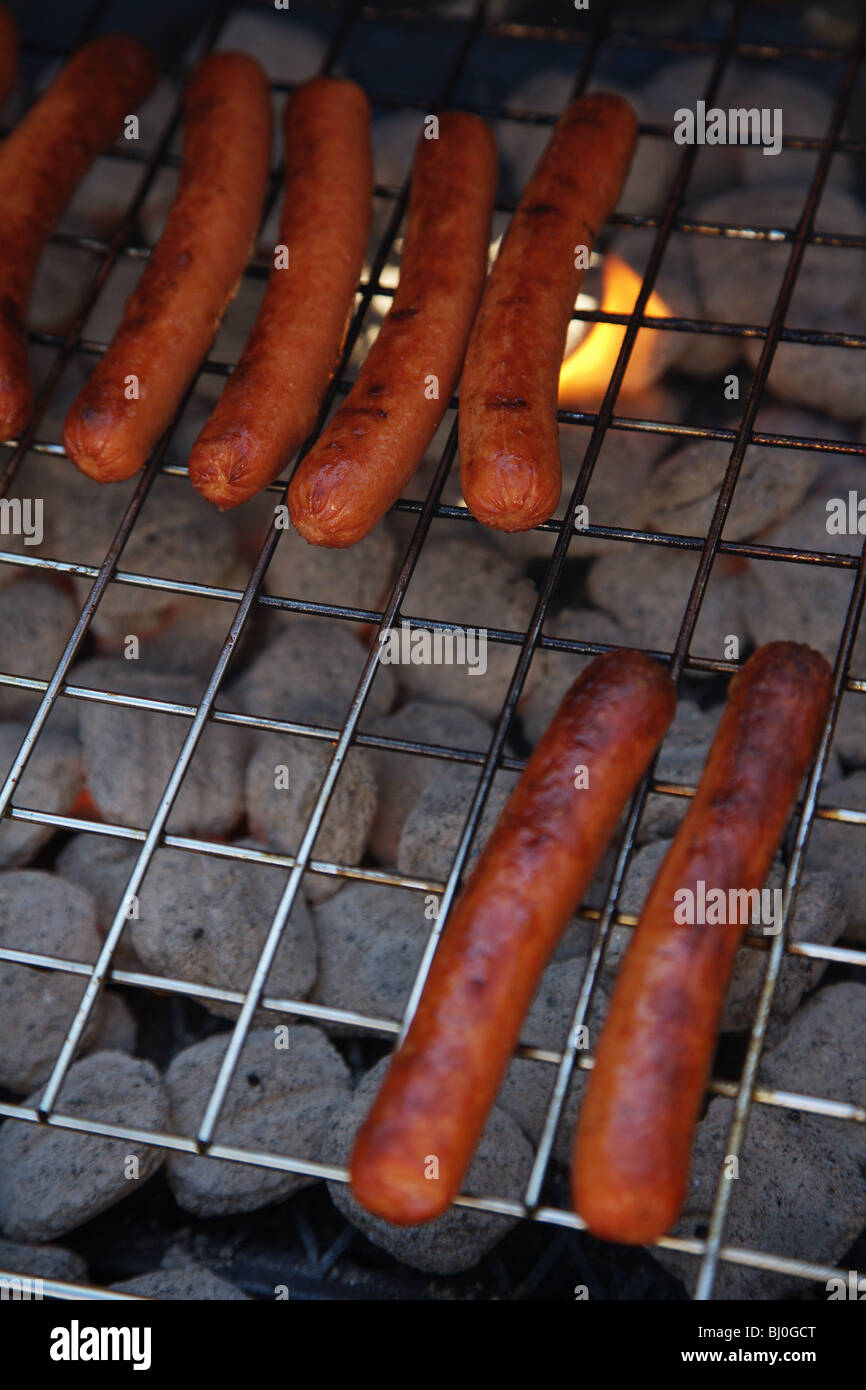CLOSEUP HOTDOGS COOKING ON A CHARCOAL GRILL LUNCH FUN FOOD COOKING