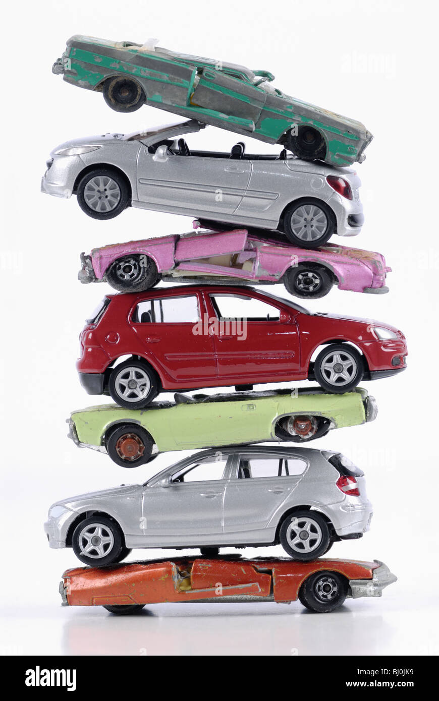 Broken and new stacked miniature cars, stagnant new cars sale after the end of scrapping bonus Stock Photo