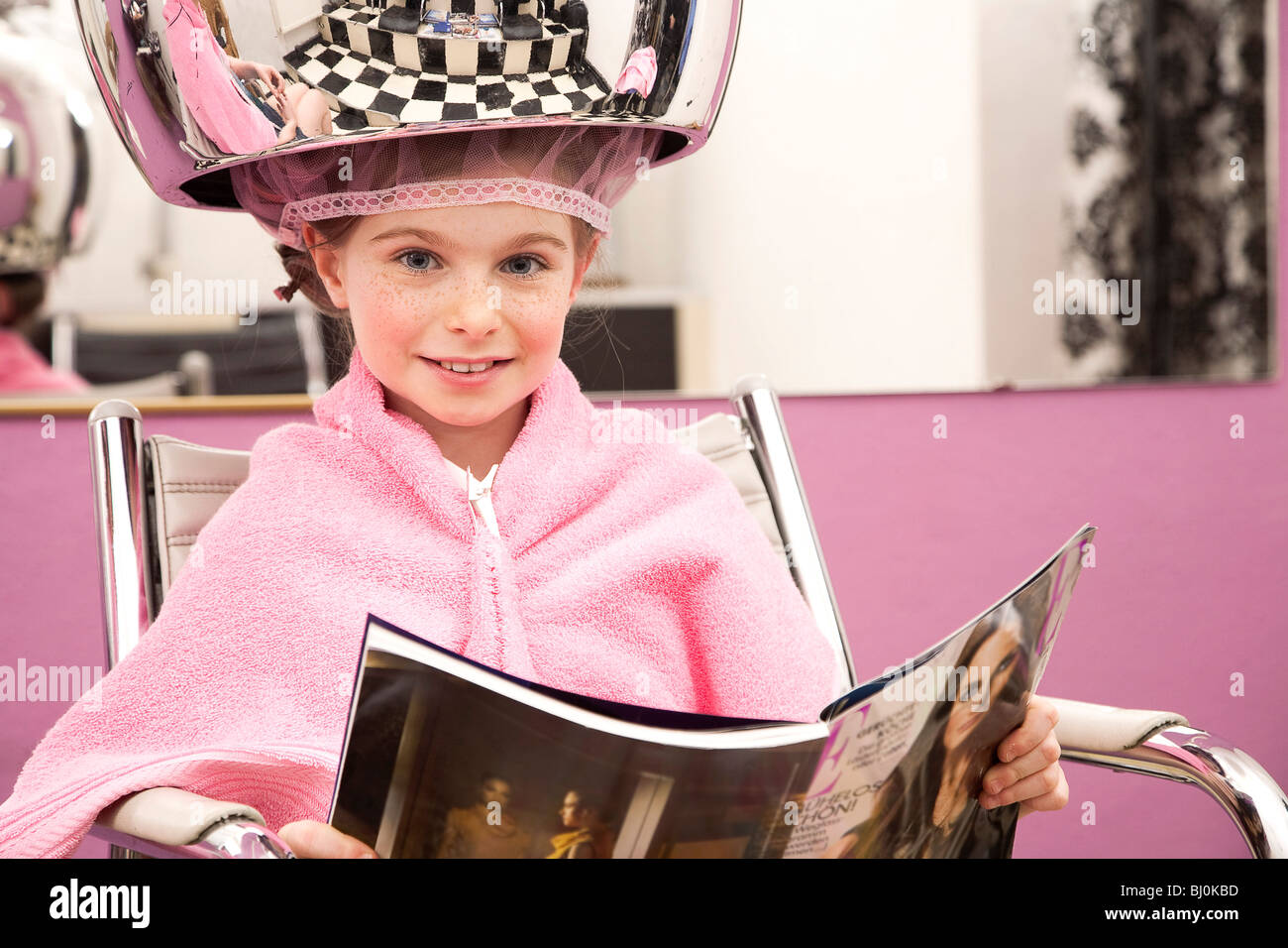 portrait of young girl sitting under hair dryer Stock Photo
