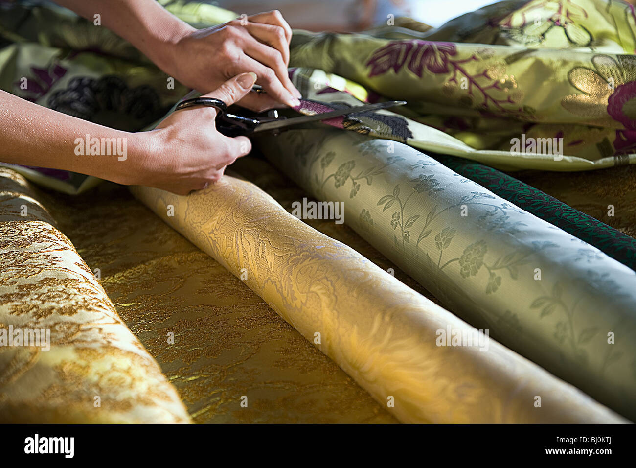 detail of woman cutting roll of cloth with scissors Stock Photo