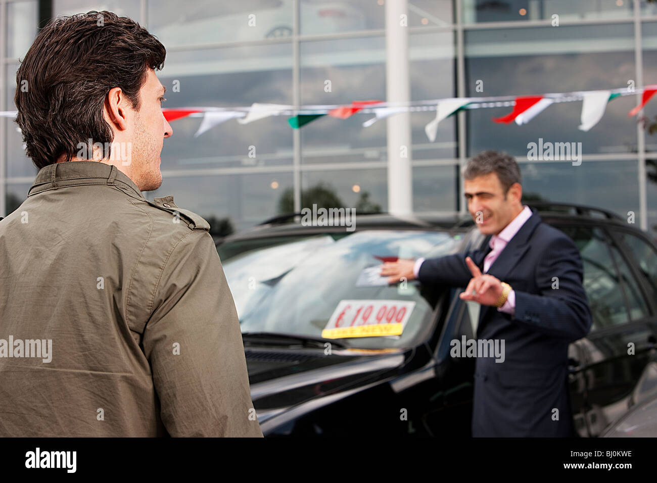 salesman at car dealer talking to customer Stock Photo Alamy