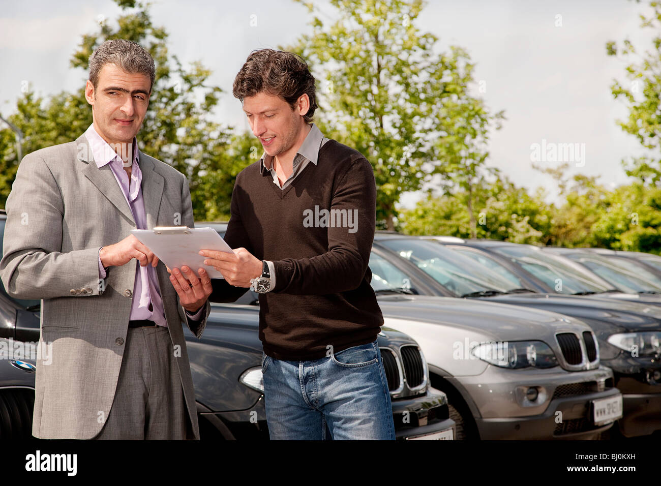 salesman and customer signing contract at car dealer Stock Photo Alamy