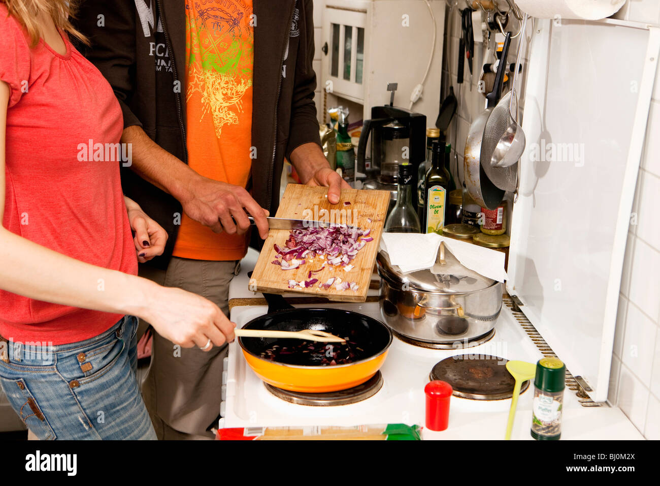 detail of young couple cooking together in kitchen Stock Photo