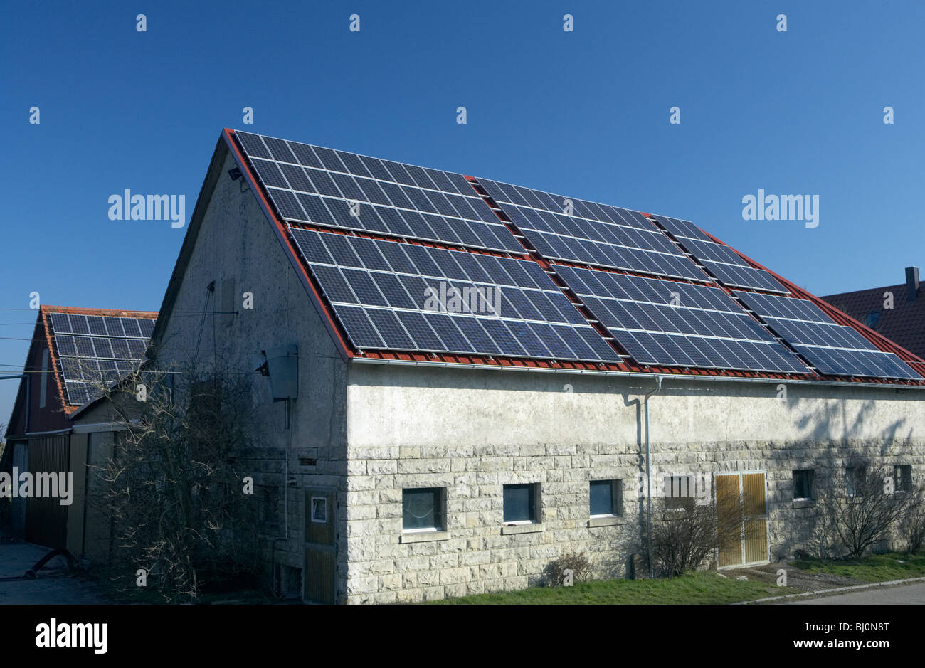 Solar cells on the roofs at a farmstead, Herboldshausen, Germany Stock Photo