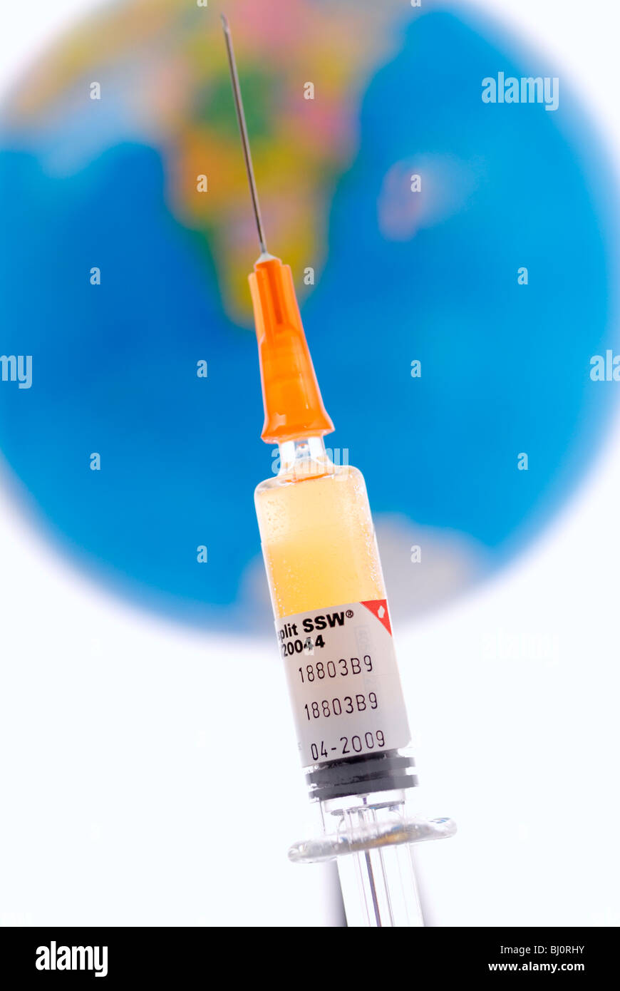 Syringe and globe, symbol photo vaccination against swine flu, pandemic Stock Photo
