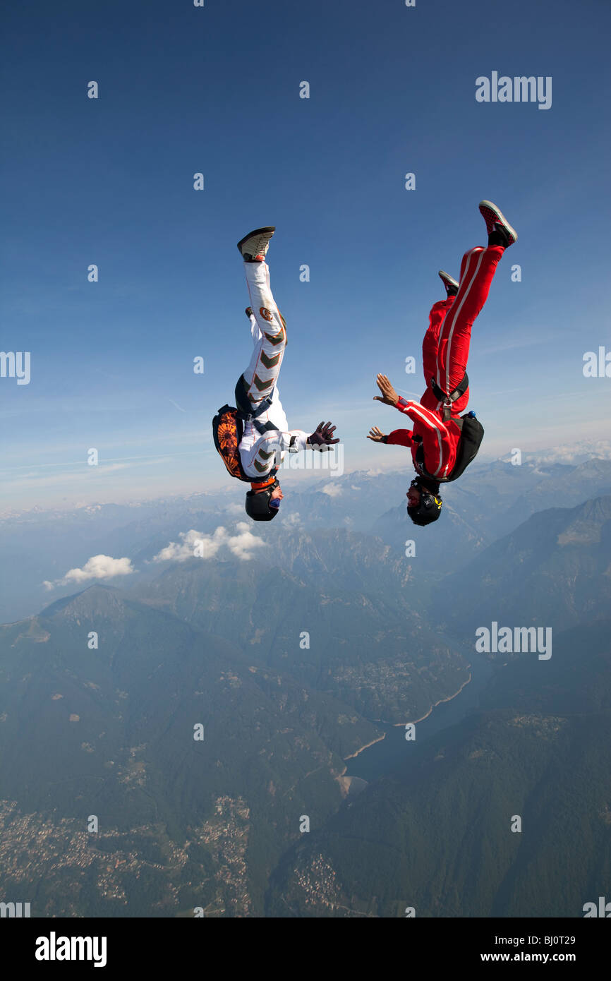 Skydiver team is flying head down. They try to give hand grips and hold ...