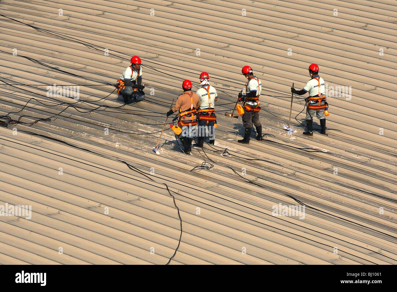 Men cleaning a roof, Hong Kong, China Stock Photo