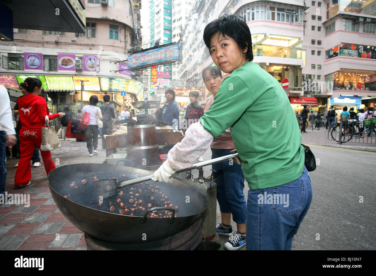 Women preparing chestnuts in a wok in Hong Kong, China Stock Photo - Alamy