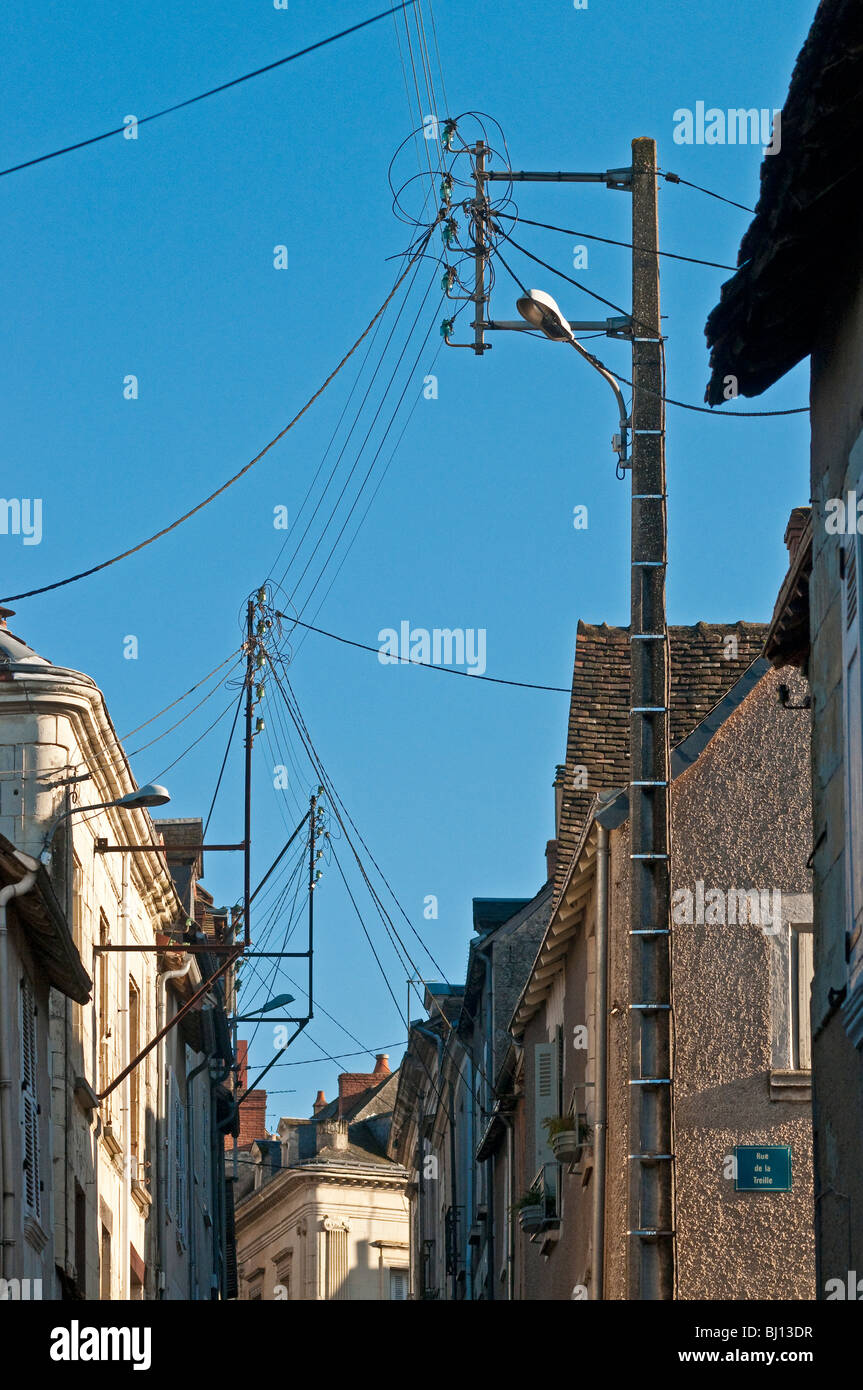 French street with old domestic mains electricity supply poles France