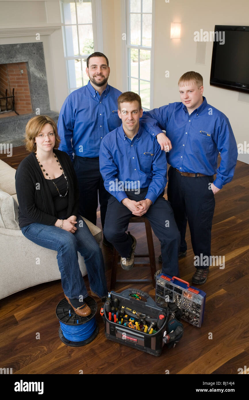 Technicians pose for group shot. They install electronics that operate an elaborate home entertainment system. Stock Photo