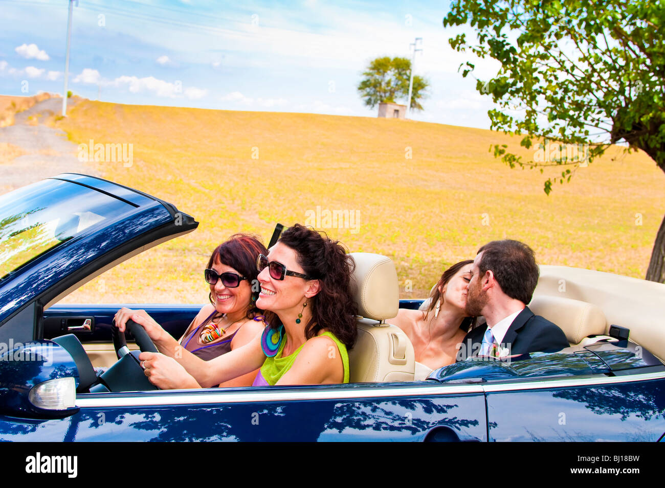 Bride and groom kissing in back of wedding convertible Stock Photo - Alamy