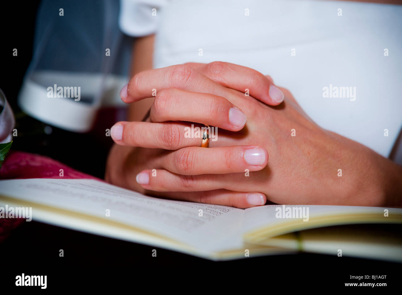 Bride wearing wedding ring with hands clasped Stock Photo