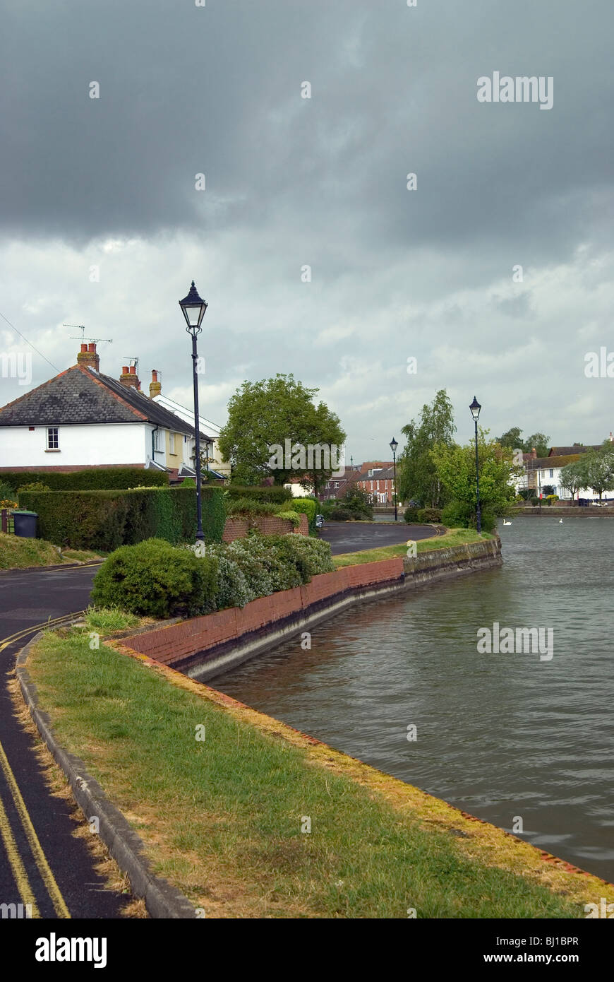 Streetlights and housing alongside emsworth mill pond hires stock